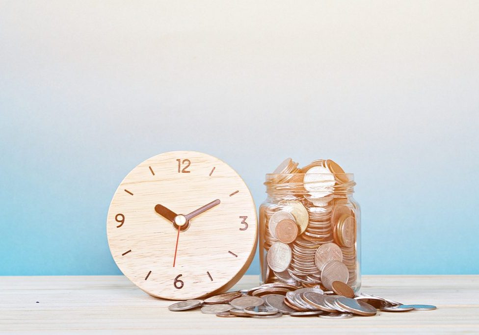 Business, savings time, time is money, deadline or delay concept : wooden alarm clock and coins on white background