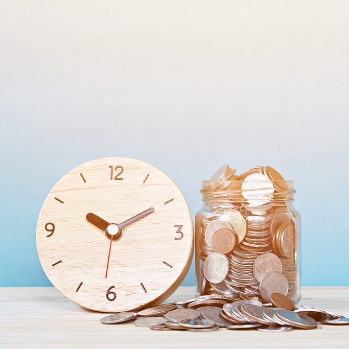Business, savings time, time is money, deadline or delay concept : wooden alarm clock and coins on white background