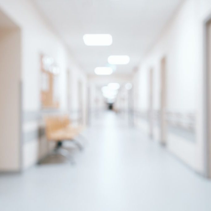 Bright, empty defocused hospital corridor background with copy space
